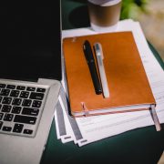 planner and pens on table with laptop
